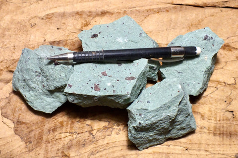 tuff - copper-stained green tuff with numerous clasts of pumice and other rock types - UNIT OF 5 student specimens
