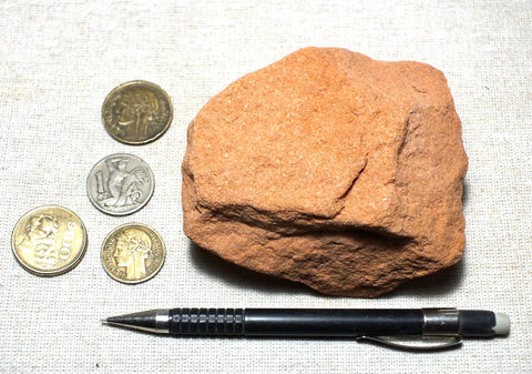 sandstone  -  teaching hand/display specimen of the Navajo Sandstone, a fine-grained orange-pink aeolian sandstone