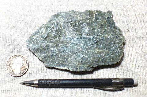 talc - clinochlore soapstone - a dark green talcose mineral - teaching hand specimen